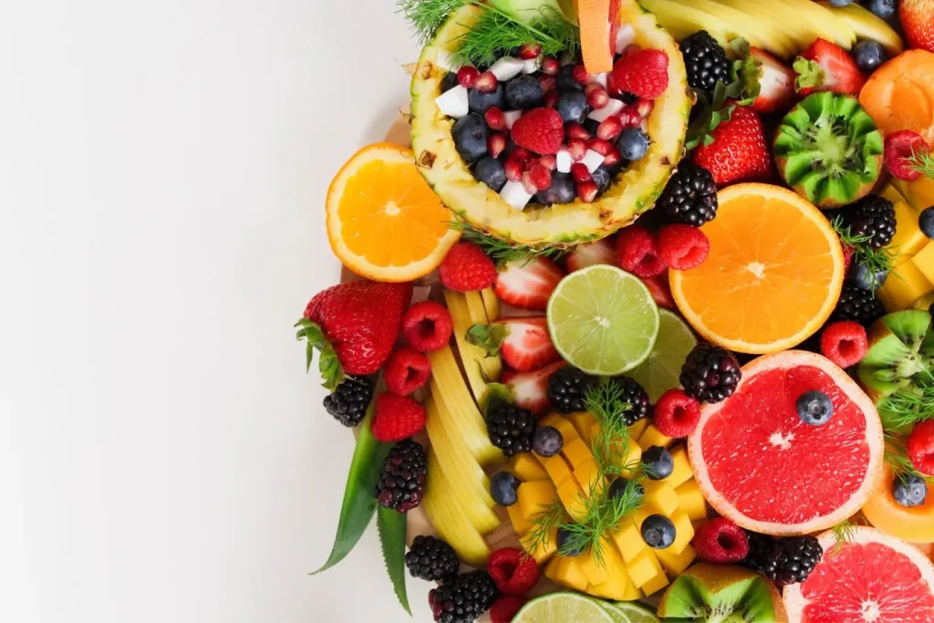 Plateau coloré de fruits frais avec agrumes, baies et kiwi, image qui illustre une alimentation riche en nutriments pour soutenir la fertilité masculine.