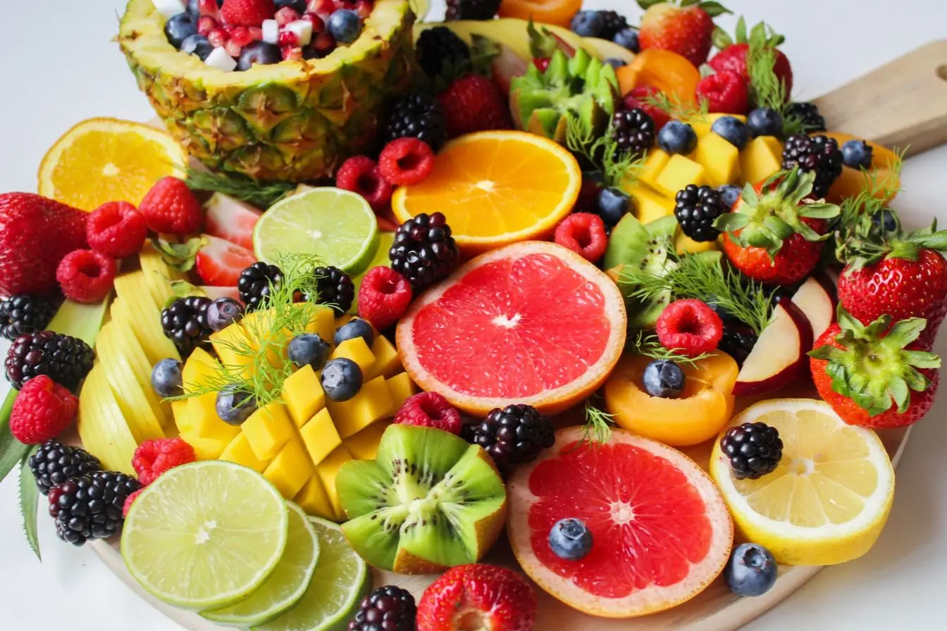 Plateau de fruits Plateau de fruits frais colorés avec agrumes, baies et kiwi, image qui illustre une alimentation riche en antioxydants pour soutenir la fertilité masculine.