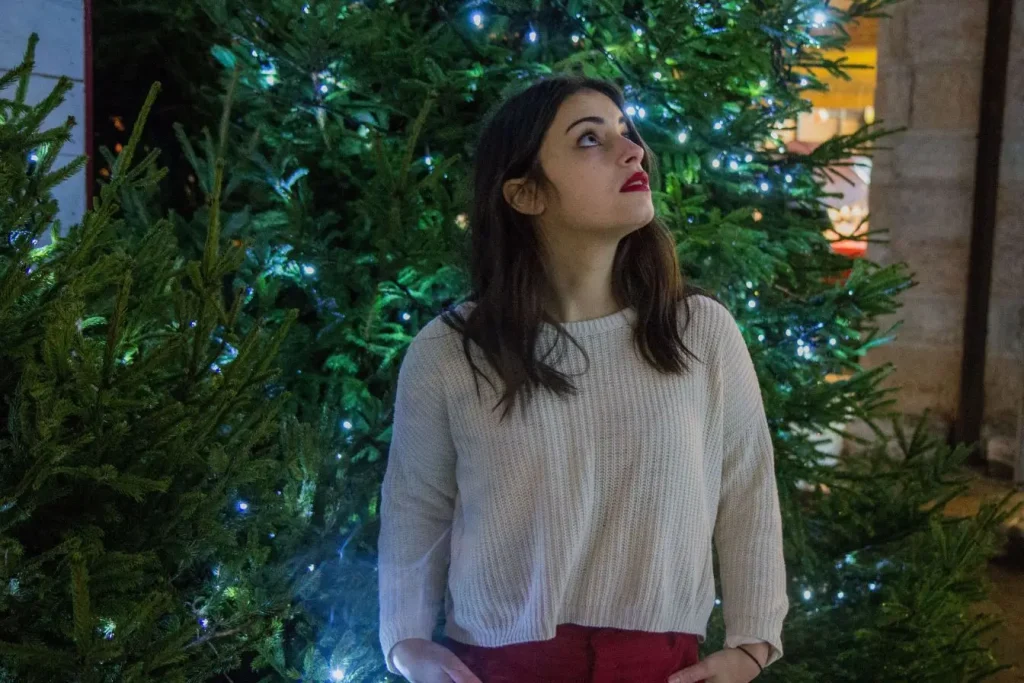 Personne debout en extérieur sous lumières décoratives, image illustrant l’effet lumineux associé aux bienfaits de la luminothérapie contre la dépression saisonnière.