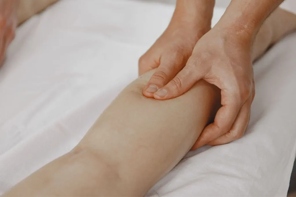 Mains appliquant un massage sur mollet allongé, image qui illustre la prévention naturelle des varices par soins et gestes simples.
