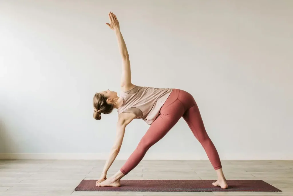 Personne en posture de yoga triangle, image illustrant une pratique douce pour stimuler le nerf vague.
