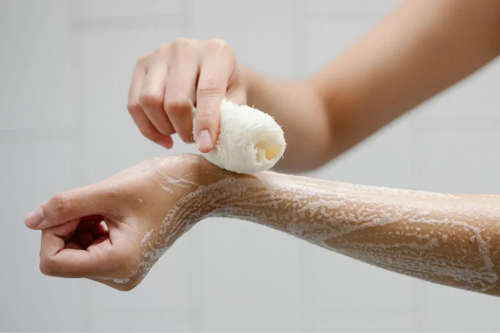 Gros plan sur bras couvert de mousse savonneuse, image illustrant un geste d’hygiène pour aider à soigner un kyste sébacé.