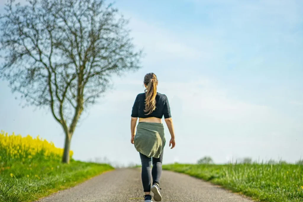 Marche tranquille dans nature, individu avançant sur sentier, illustrant soin du lumbago par activité douce.