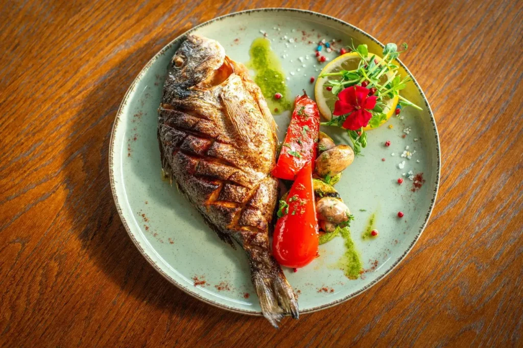 Assiette colorée avec poisson grillé et légumes variés, image qui illustre une alimentation équilibrée bénéfique pour la santé cardiovasculaire.