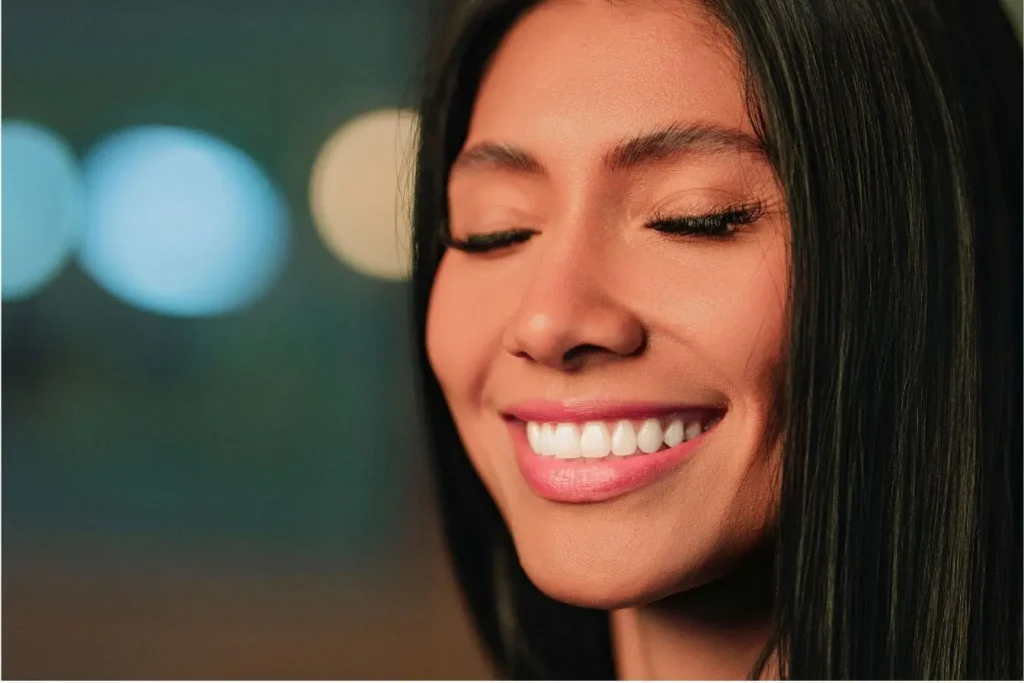 Gros plan sur visage souriant aux dents blanches et alignées, reflet d’une bonne santé bucco-dentaire.