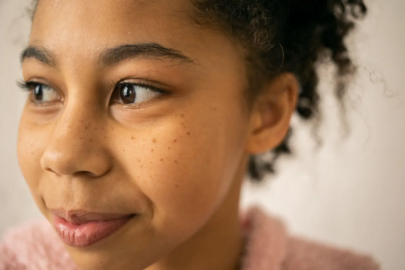 cernes creux Visage naturel avec cheveux bouclés et regard marqué, illustration des causes des cernes creux.