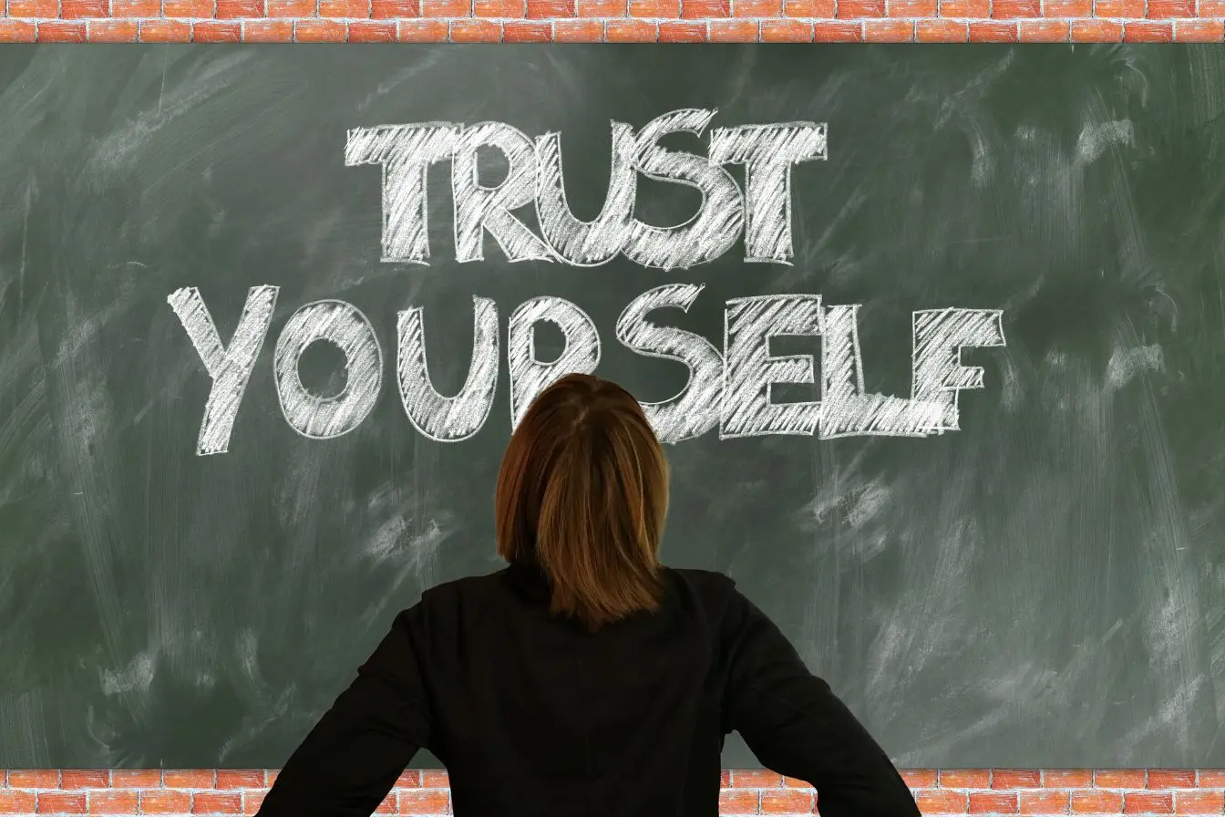 développement de la confiance en soi Personne debout face à un tableau portant un message inspirant, illustrant le travail quotidien nécessaire pour développer sa confiance en soi