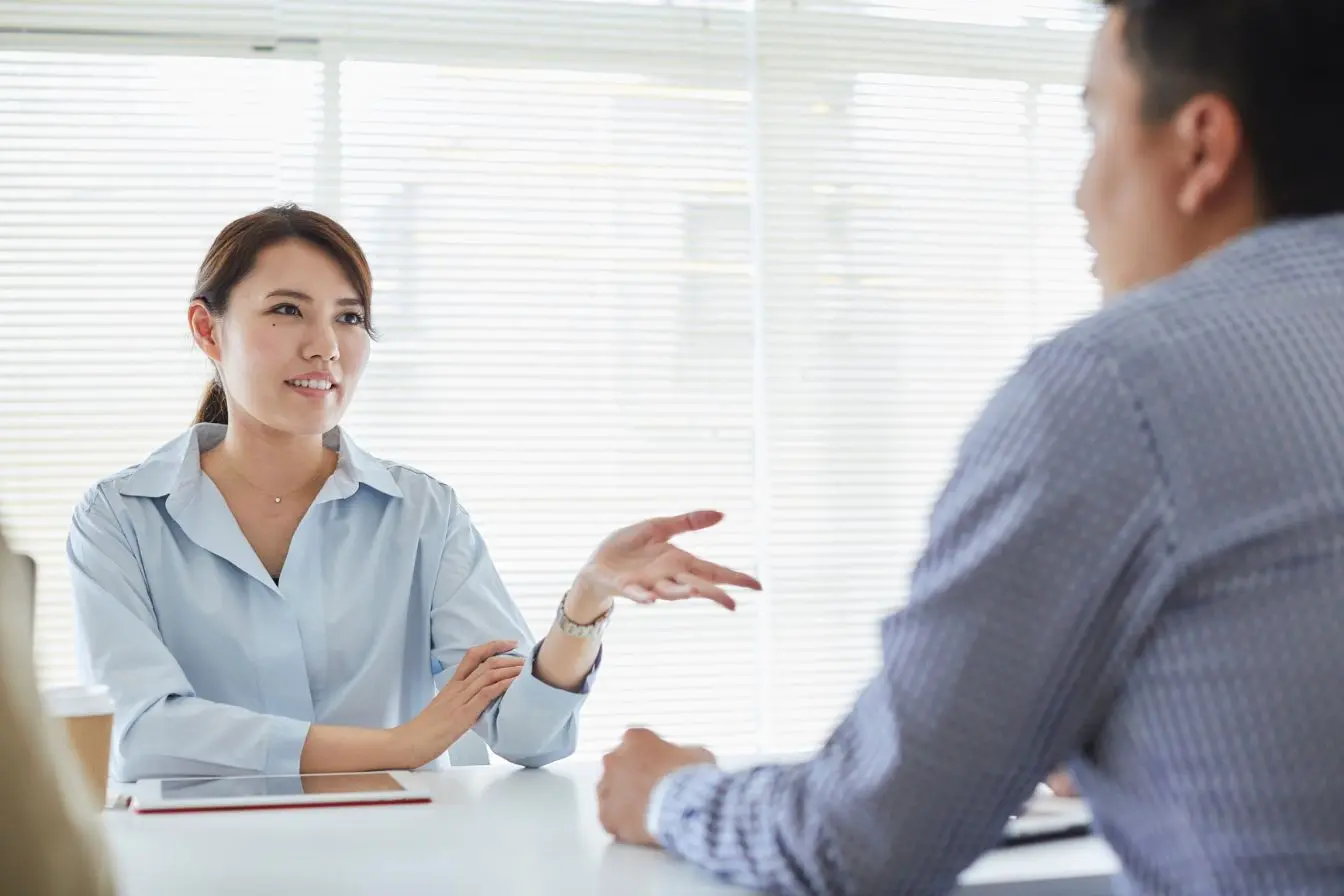 poser ses limites avec ses proches Une femme exprime son point d'avis avec assurance face à un interlocuteur pour illustrer l'art de poser ses limites et préserver son équilibre.